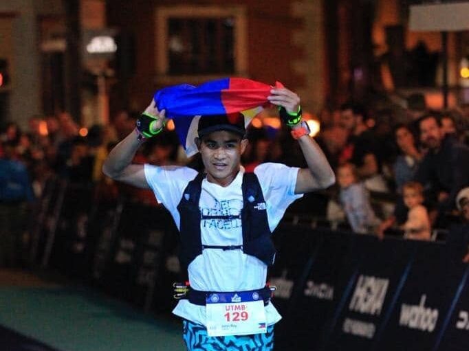 John Ray Onifa crossing the UTMB Mont-Blanc finish line with the Philippine flag over his head