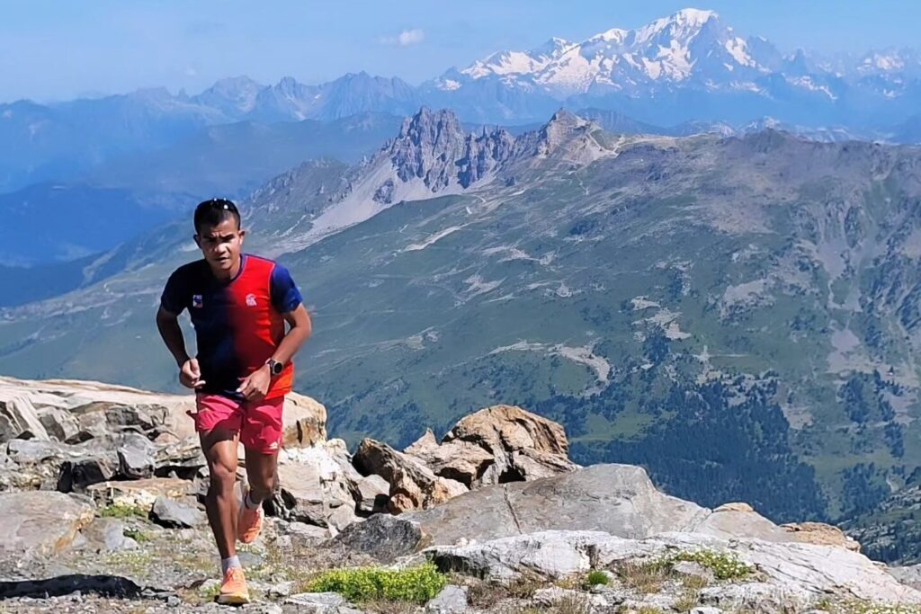 John Ray Onifa running on a rocky ridge with Mont Blanc in the background