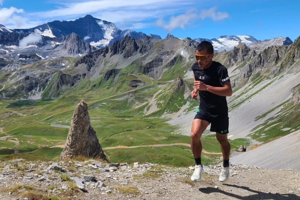 John Ray Onifa running uphill on an Alpine trail